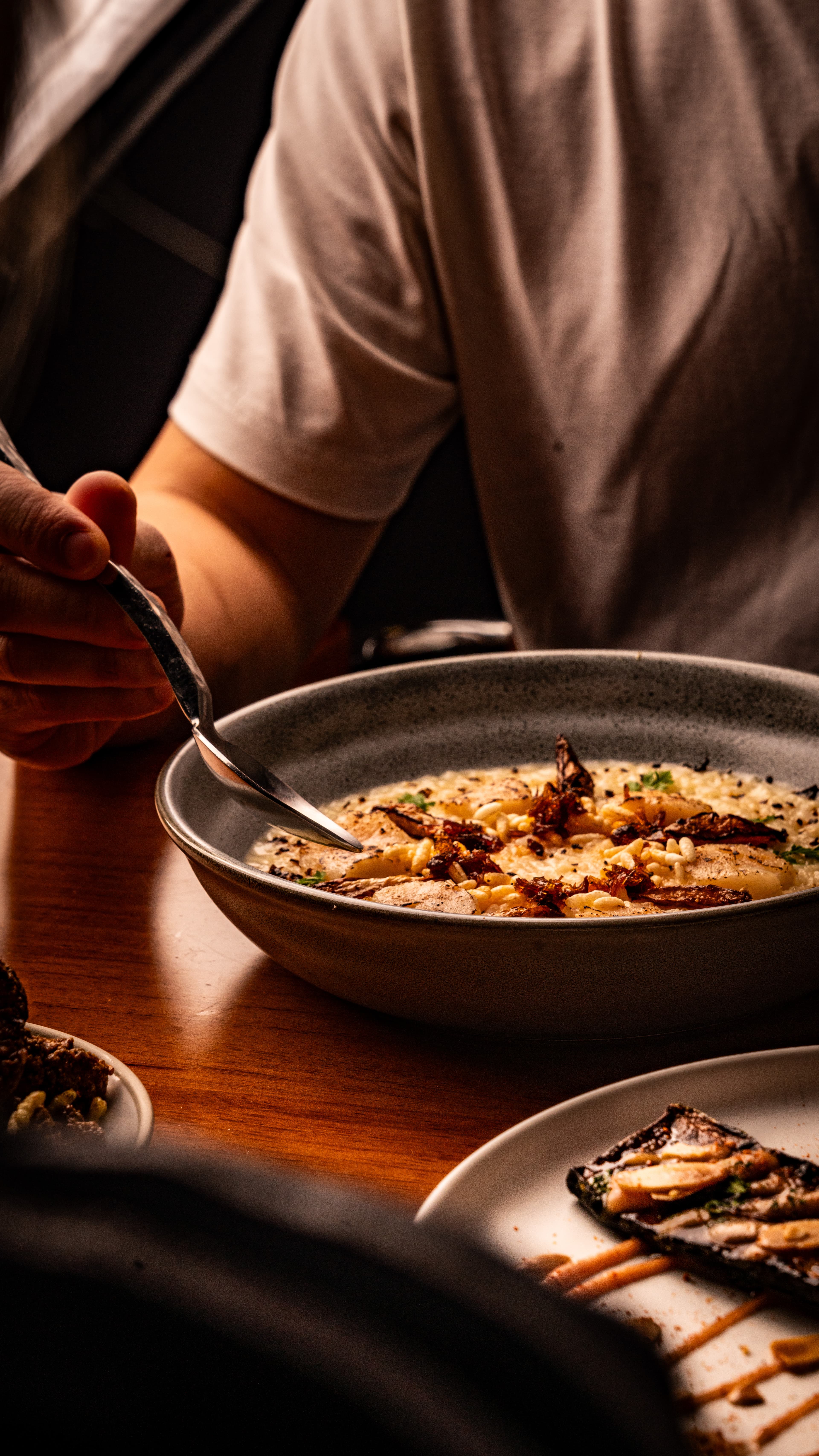 Man eating creamy risotto at To;asta.